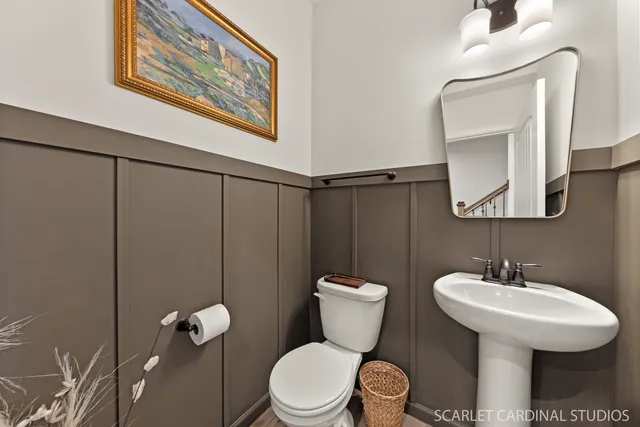 a bathroom with a toilet sink and mirror