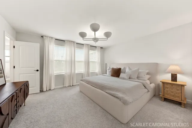 a spacious bedroom with a bed and a chandelier