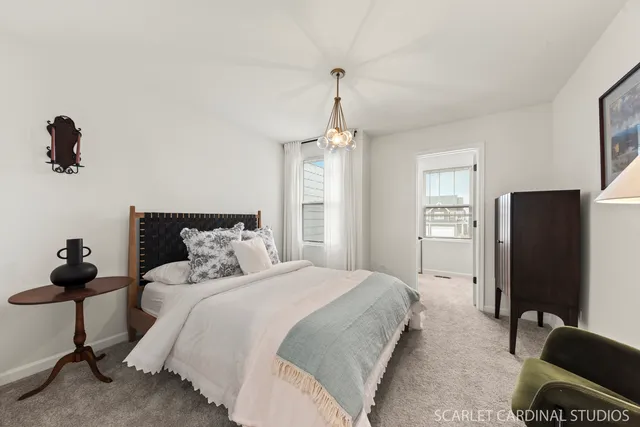 a bedroom with bed mirror and window
