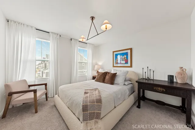 a bedroom with a bed and a table in it with window