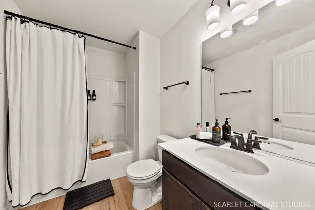 a bathroom with a sink a toilet a mirror and shower