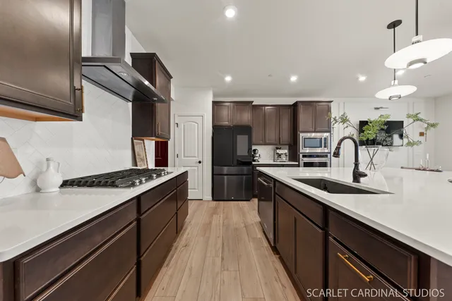 a kitchen with kitchen island granite countertop a sink stainless steel appliances and cabinets