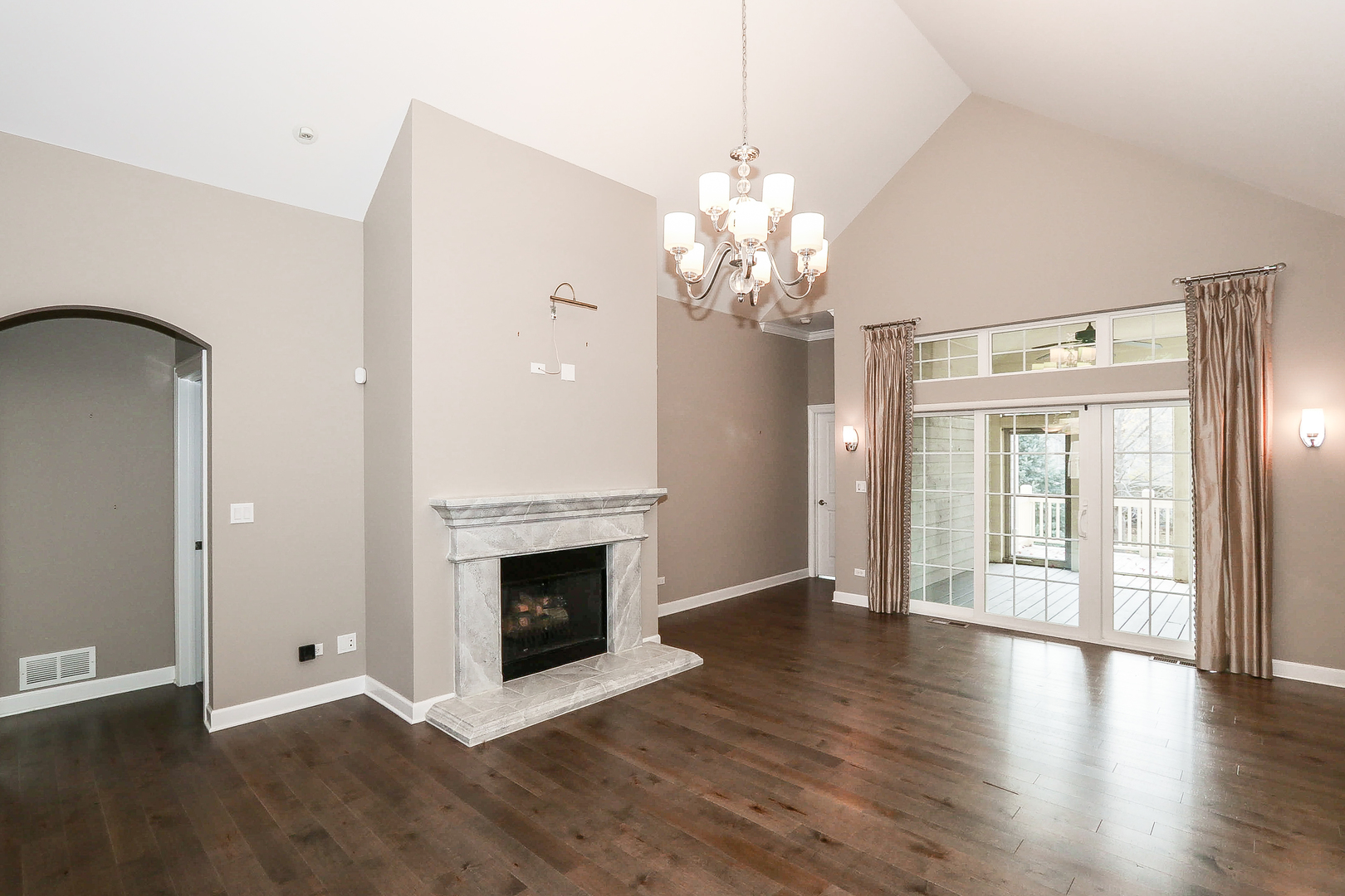 6 Sugar Maple Court Lake In The Hills, IL 60156 - Photo 4 of 35 an empty room with wooden floor fireplace and chandelier
