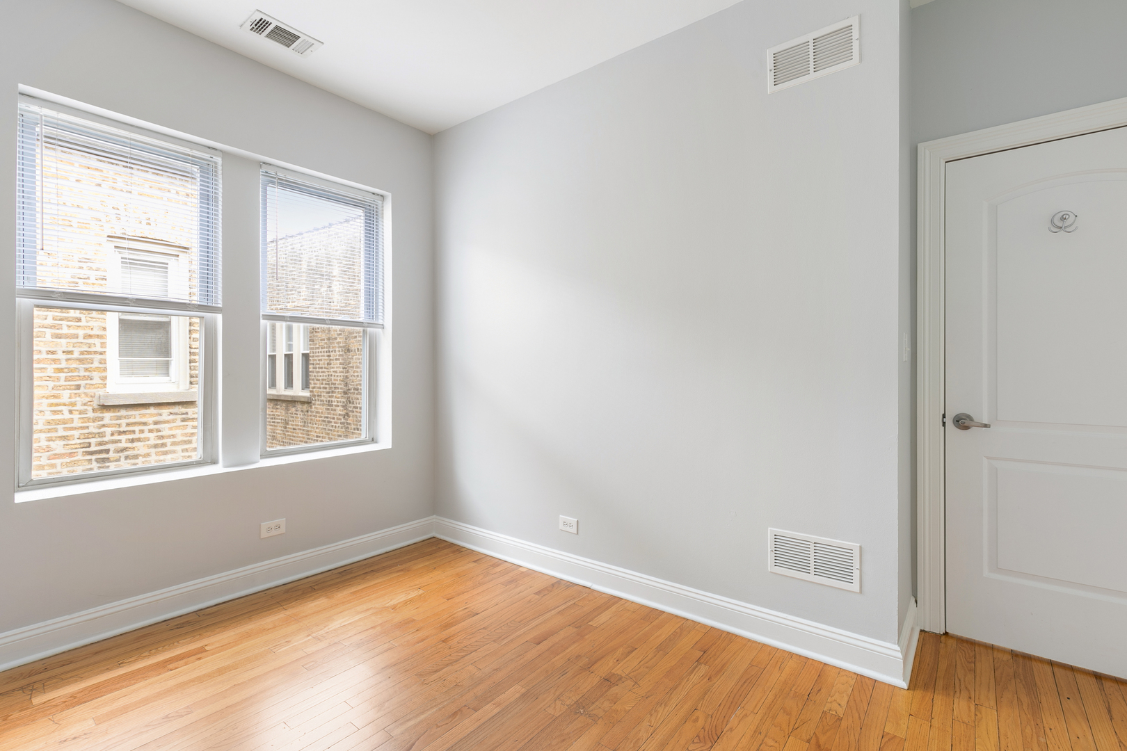 2007 West Jarvis Avenue, Unit 3 Chicago, IL 60645 - Photo 13 of 18 a view of an empty room with wooden floor and a window