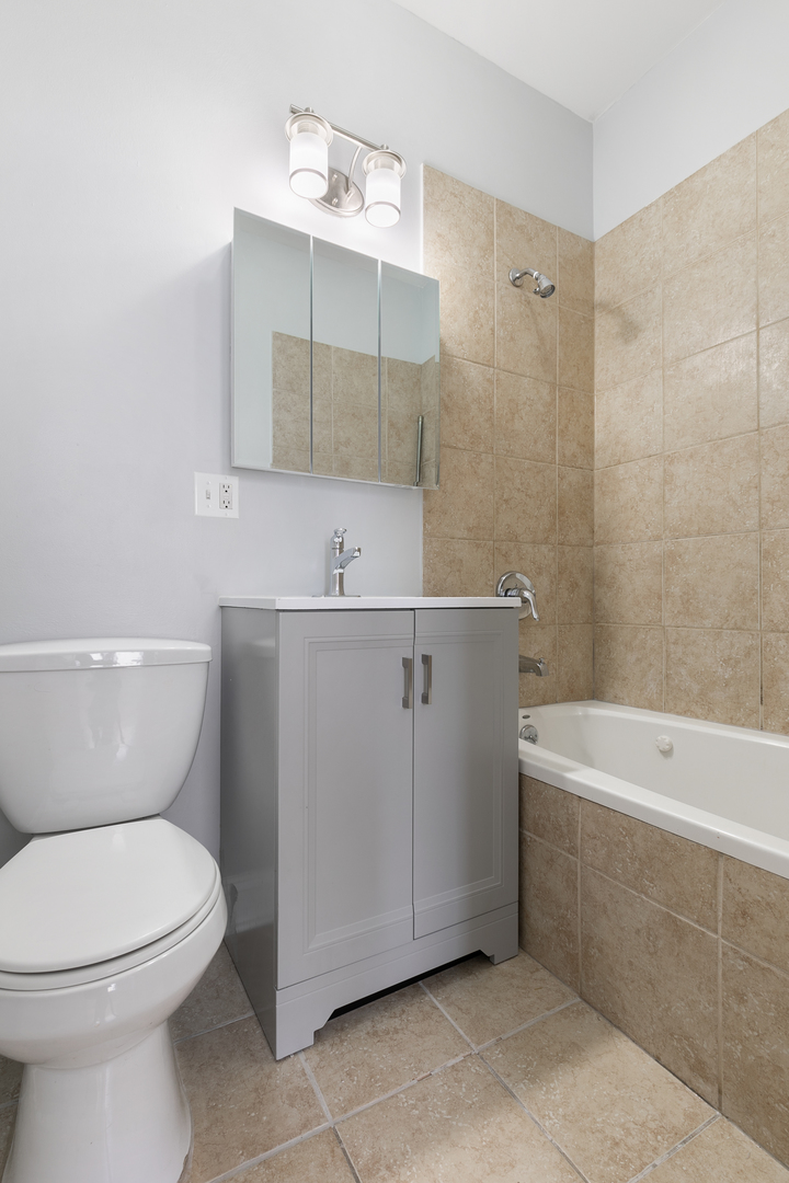 2007 West Jarvis Avenue, Unit 3 Chicago, IL 60645 - Photo 14 of 18 a bathroom with a sink a toilet and shower