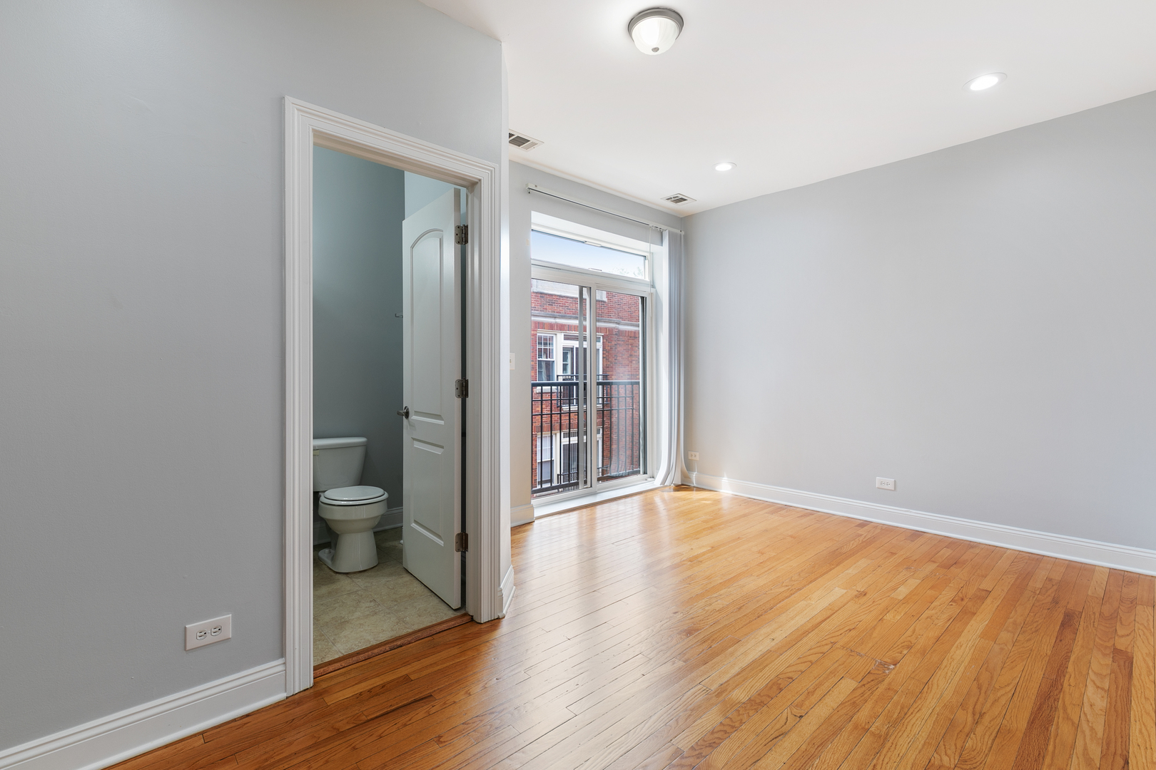 2007 West Jarvis Avenue, Unit 3 Chicago, IL 60645 - Photo 5 of 18 an empty room with wooden floor and a toilet