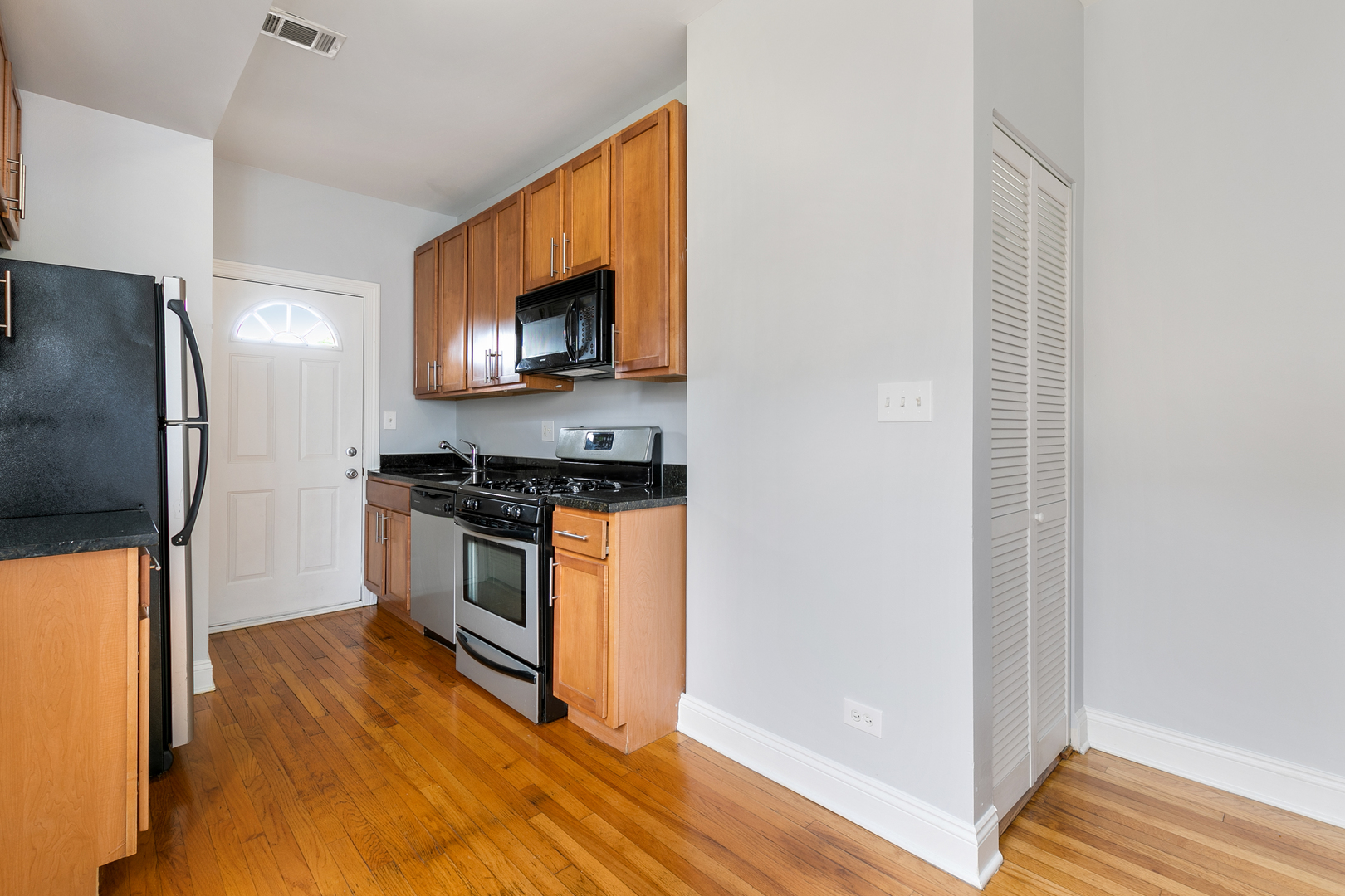 2007 West Jarvis Avenue, Unit 3 Chicago, IL 60645 - Photo 6 of 18 a kitchen with stainless steel appliances a refrigerator stove and microwave