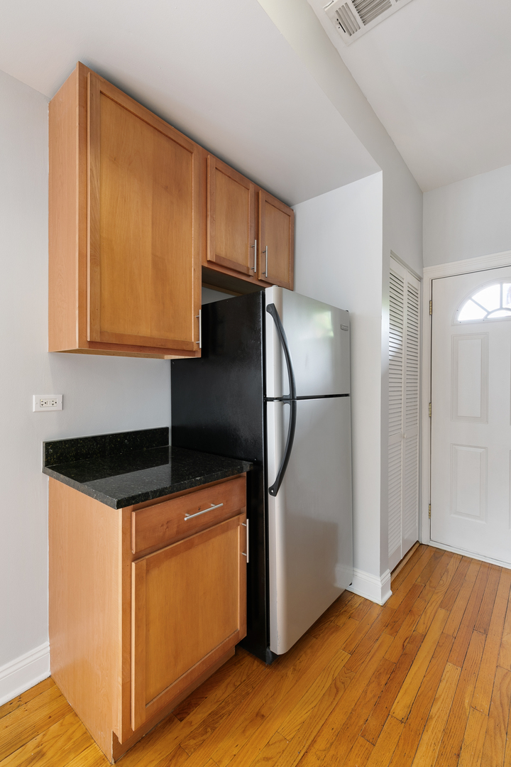 2007 West Jarvis Avenue, Unit 3 Chicago, IL 60645 - Photo 8 of 18 a kitchen with stainless steel appliances granite countertop a refrigerator sink and cabinets