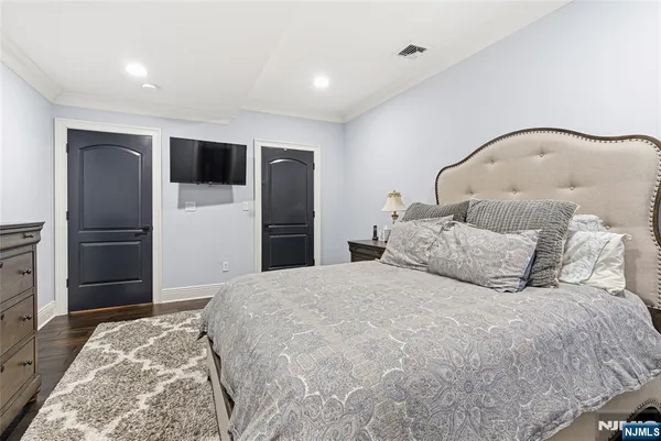 a bedroom with a large bed and a refrigerator