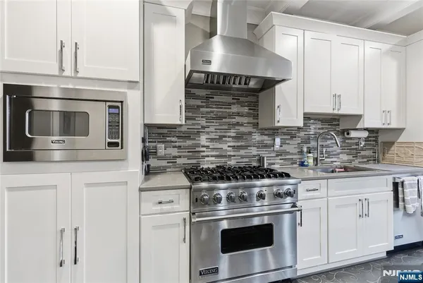 a kitchen with granite countertop white cabinets stainless steel appliances and sink