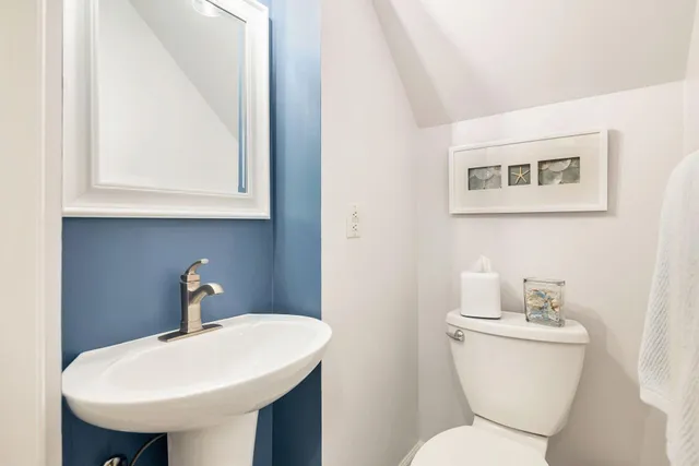 a bathroom with a toilet a sink and a mirror