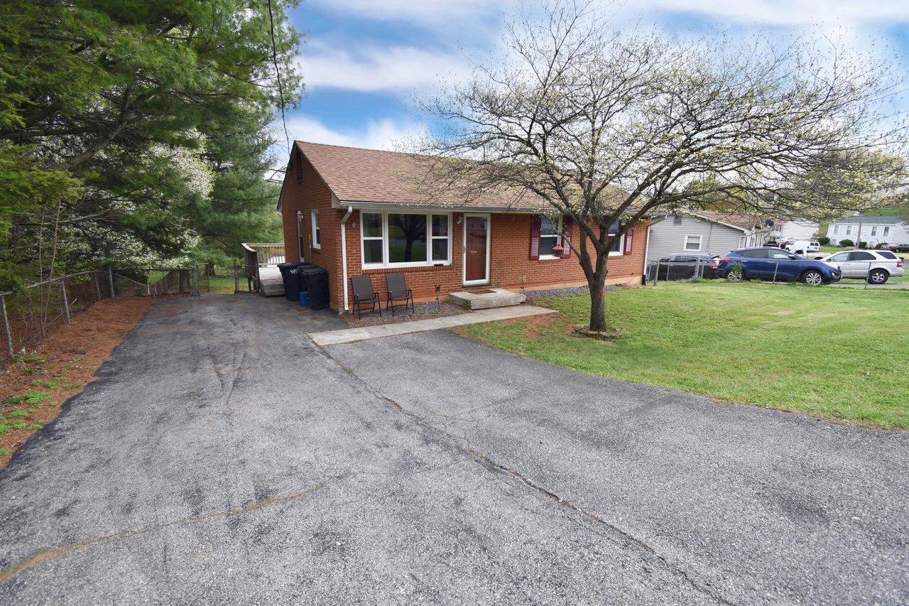 a view of a house with a yard and large tree