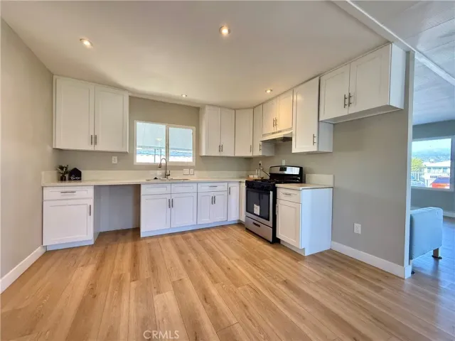 a kitchen with wooden floors stainless steel appliances and cabinets