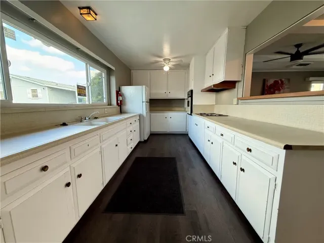 a large white kitchen with a large window