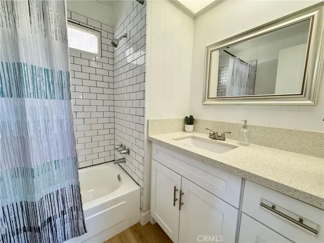 a bathroom with a tub sink and mirror