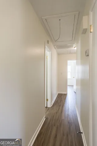 a view of a hallway with wooden floor