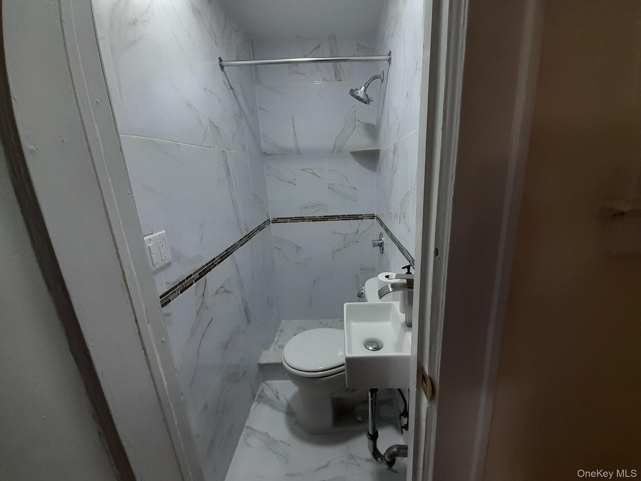 159-32 Normal Road, Unit 2 Queens, NY 11432 - Photo 8 of 13 a bathroom with a granite countertop shower and a toilet