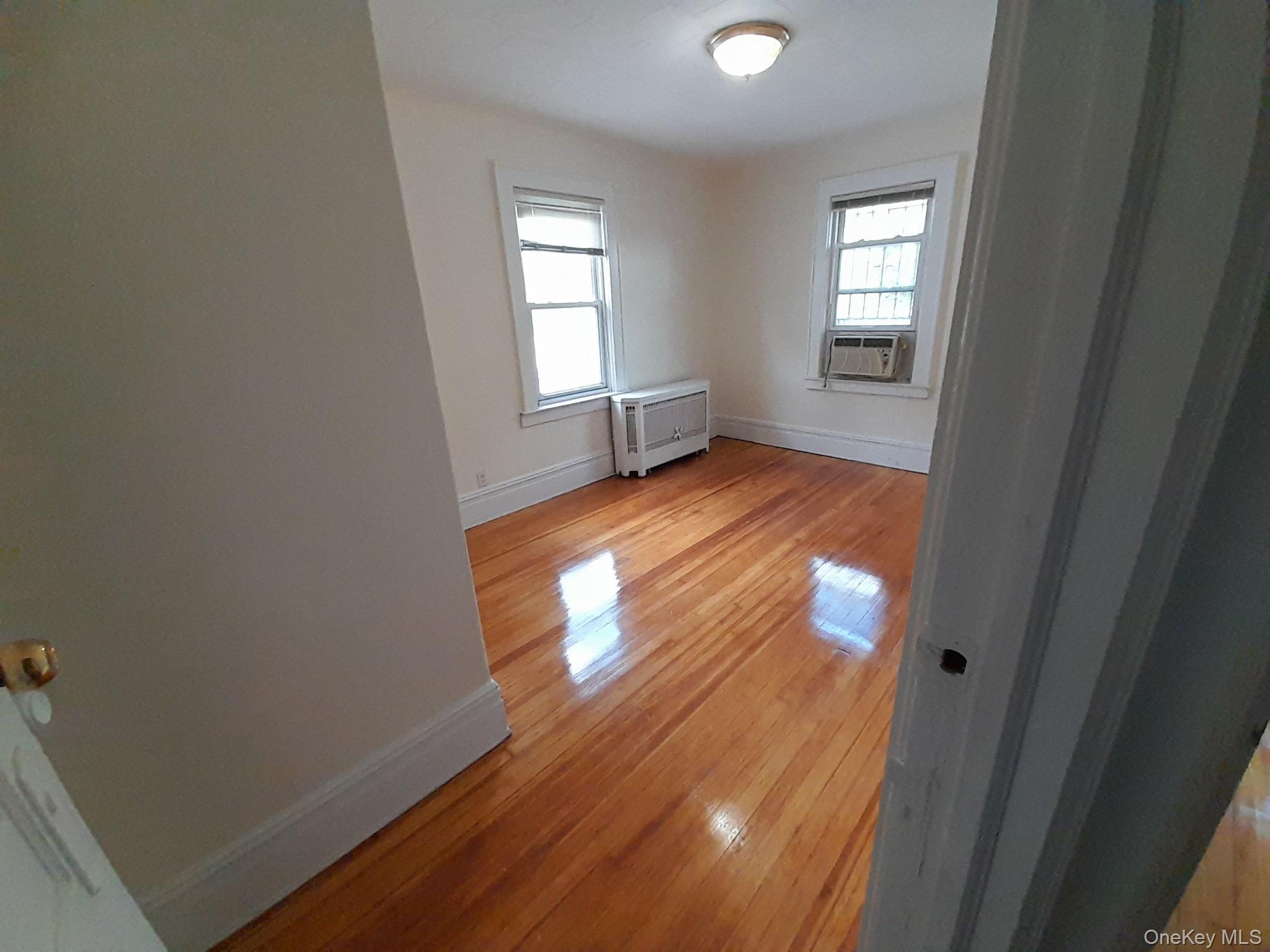 159-32 Normal Road, Unit 2 Queens, NY 11432 - Photo 10 of 13 a view of empty room with window and wooden floor