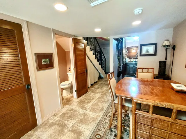 a kitchen with stainless steel appliances kitchen island granite countertop a stove a sink a dining table and chairs