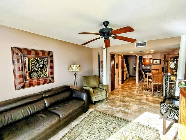a living room with furniture and a ceiling fan
