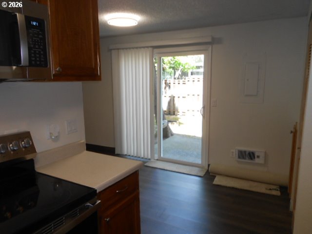 17165 Southwest Merlo Road Beaverton, OR 97003 - Photo 12 of 19 a view of a kitchen with a fridge and wooden floor