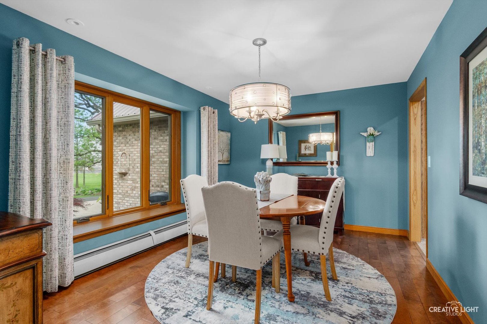 14050 Townhouse Road Newark, IL 60541 - Photo 8 of 45 a dining room with wooden floor a chandelier a wooden table and chairs