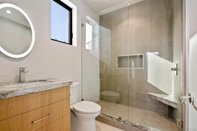 a bathroom with a sink a toilet and shower