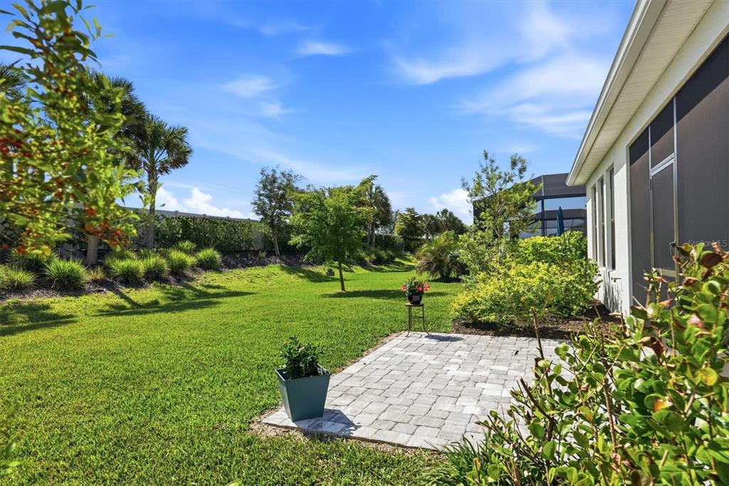 9268 Tequila Sunrise Drive Sarasota, FL 34241 - Photo 33 of 56 a view of a garden with a building in the background