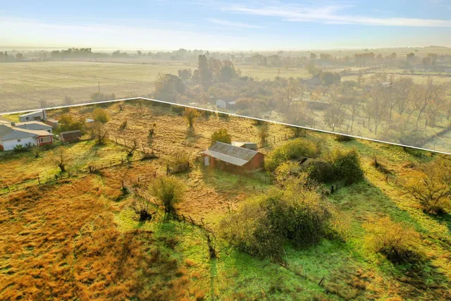 an aerial view of residential houses with outdoor space and ocean