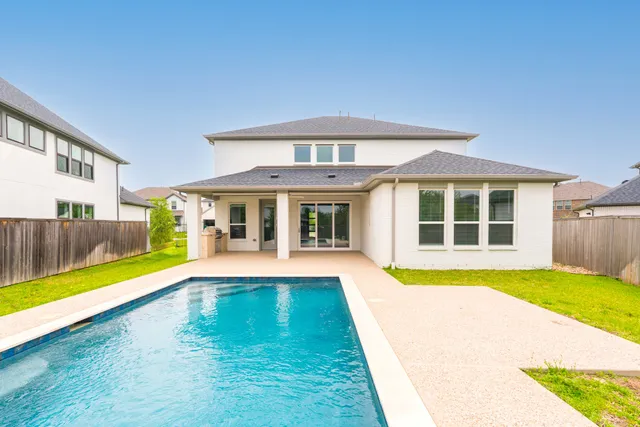 a view of a house with swimming pool and a yard