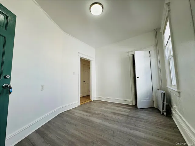 an empty room with wooden floor and a window
