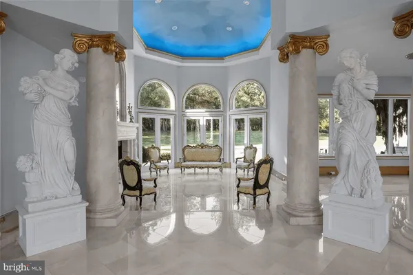 a living room with couches chairs and a fireplace with wooden floor