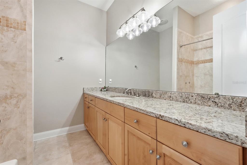 6595 Collier Road St. Augustine, FL 32092 - Photo 38 of 98 a bathroom with a granite countertop sink and a mirror