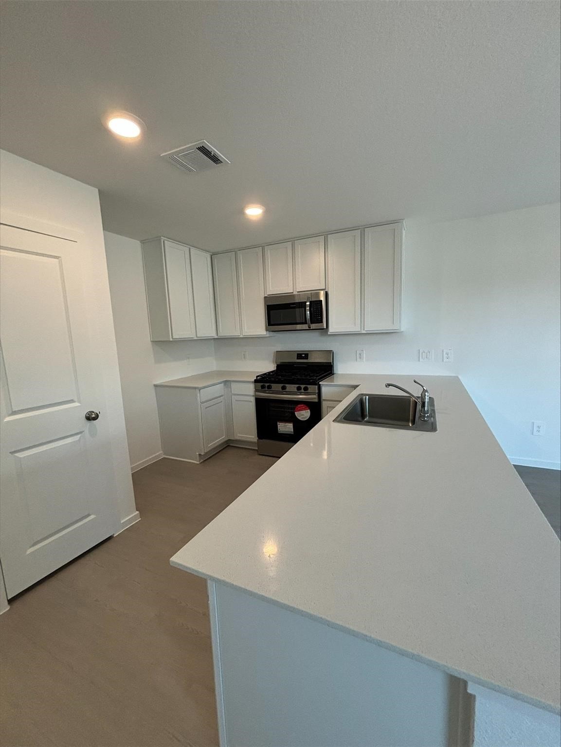 658 Maria Elena Way Cleveland, TX 77327 - Photo 4 of 24 a kitchen with granite countertop a refrigerator sink and white cabinets