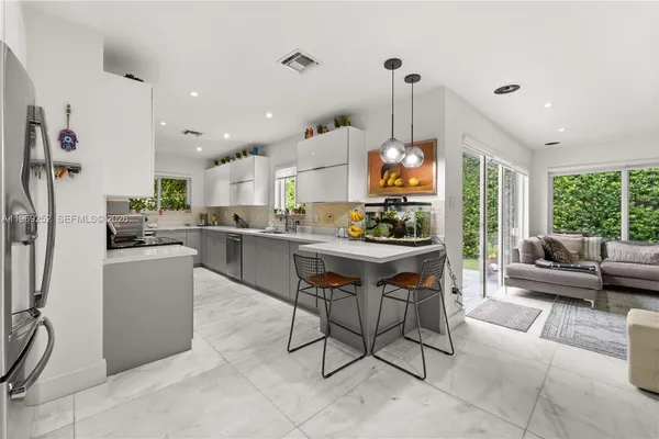 a living room with stainless steel appliances kitchen island granite countertop furniture and a view of kitchen