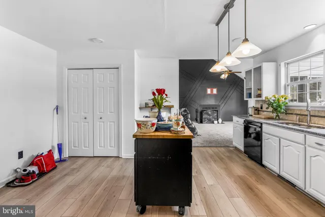 a living room with kitchen island furniture and a chandelier
