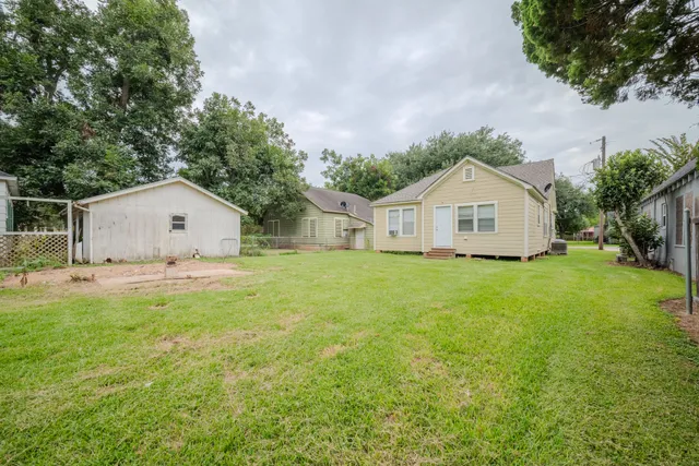 a view of a house with a yard and fence