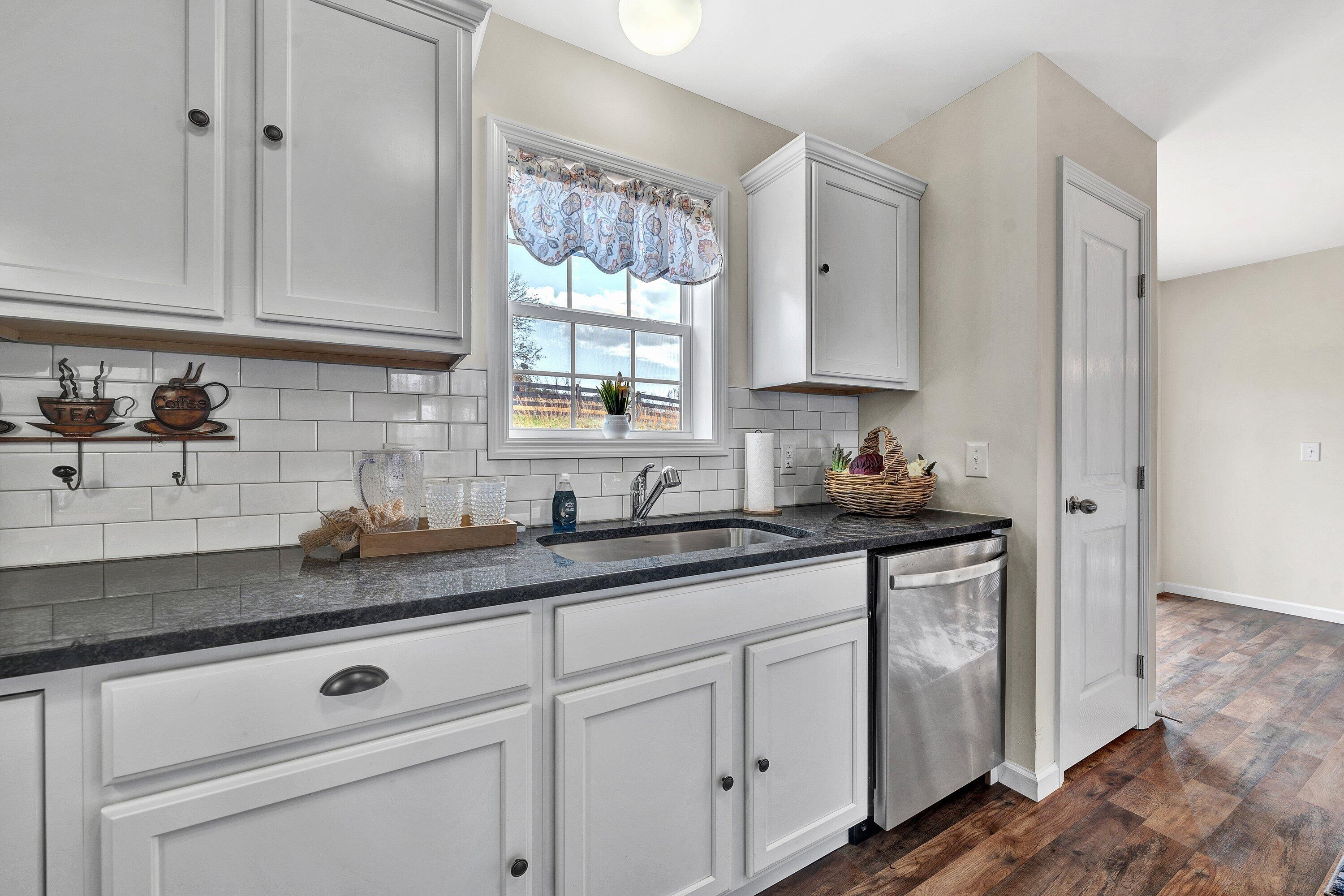 6507 Goodview Road Goodview, VA 24095 - Photo 11 of 28 a kitchen with granite countertop white cabinets and white appliances