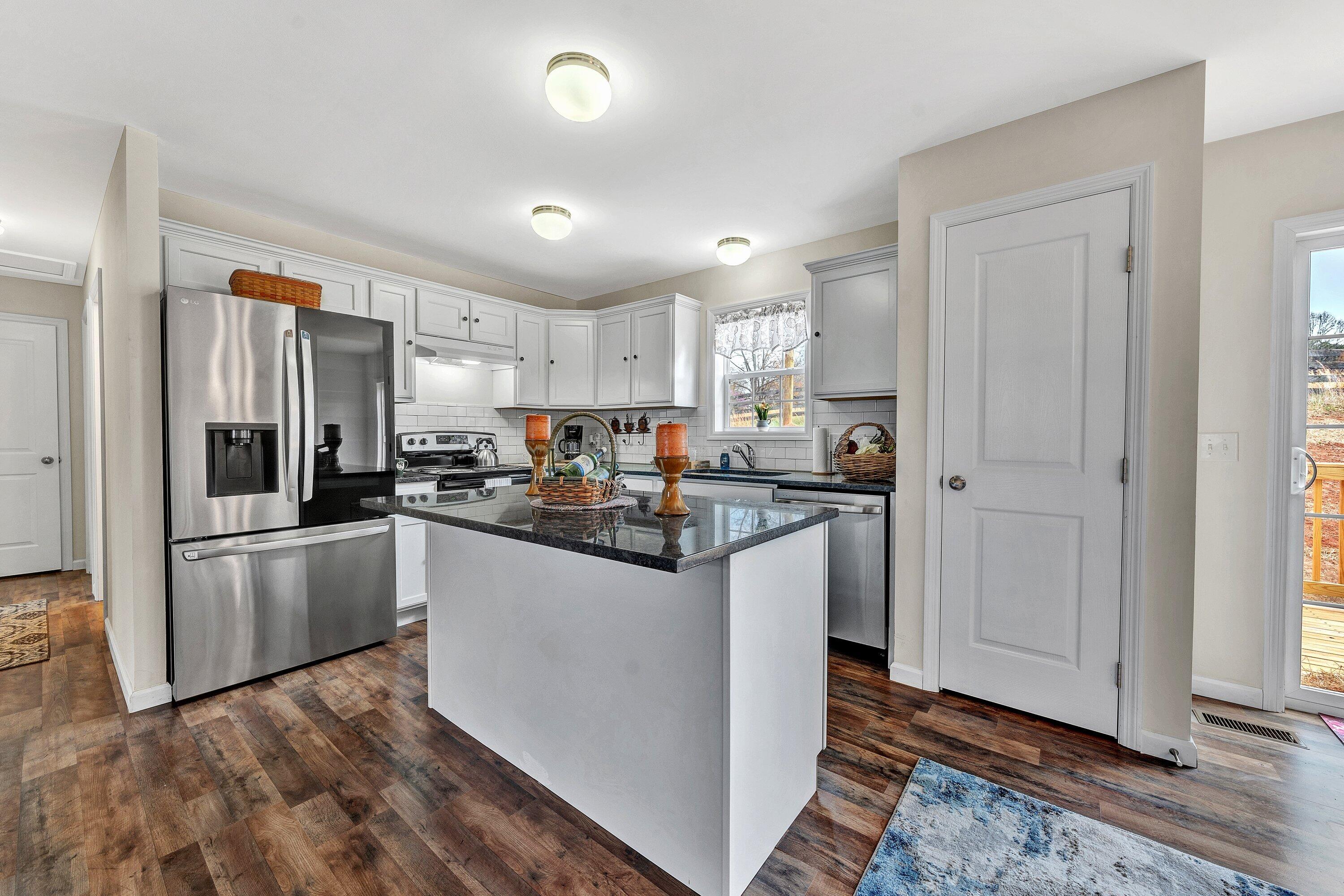 6507 Goodview Road Goodview, VA 24095 - Photo 8 of 28 a kitchen with granite countertop a refrigerator and a sink