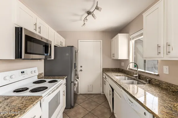 a kitchen with stainless steel appliances granite countertop a stove a sink and a microwave