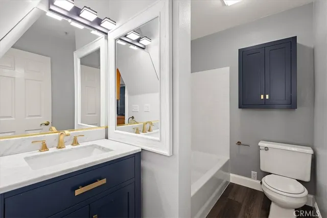 a bathroom with a sink a toilet a mirror and shower