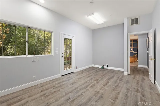 an empty room with wooden floor and windows