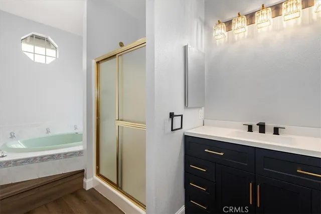 a bathroom with a double vanity sink and mirror with bathtub