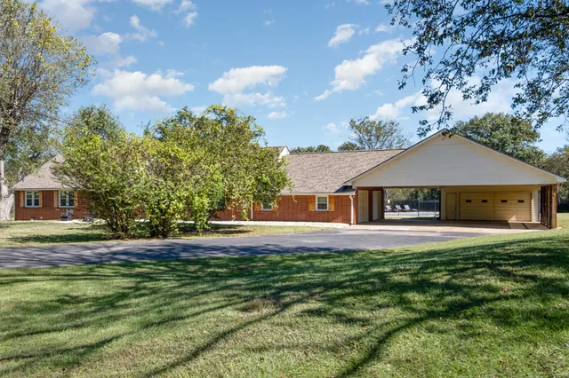 a front view of house with yard and trees in the background