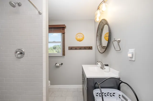 a bathroom with a sink a mirror and shower