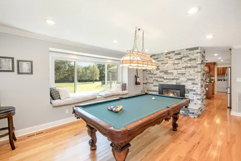 a room with pool table and windows