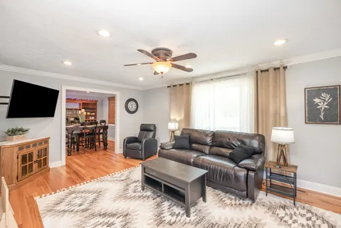 a living room with furniture flat screen tv and wooden floor