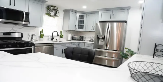 a kitchen with stainless steel appliances a refrigerator stove microwave and sink