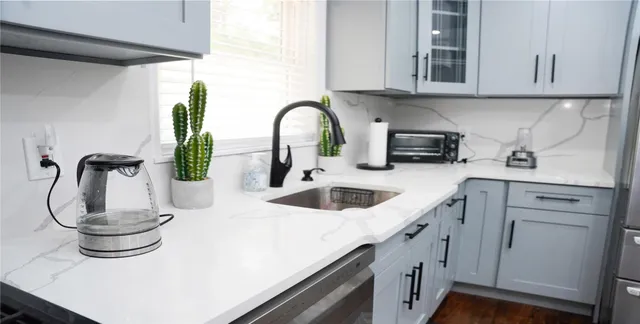 a kitchen with stainless steel appliances a sink a stove and cabinets