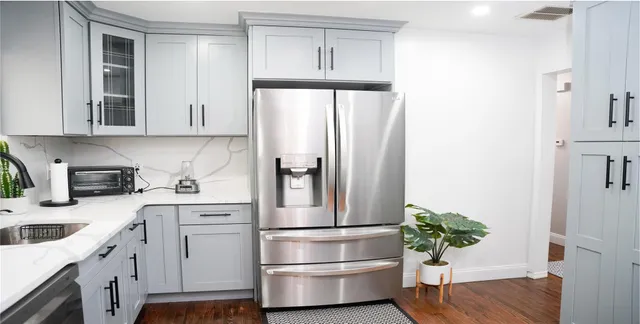 a kitchen with stainless steel appliances a refrigerator sink and cabinets